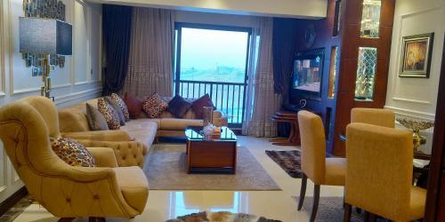 a living room with a couch and a table and chairs at دوبلوكس نيو بورتو كايرو القاهرة الجديدة للعائلات فقط in Cairo