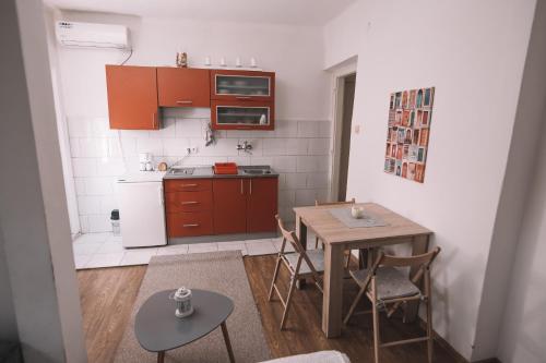 a small kitchen with a table and a table and chairs at De lux Apartment & Rooms Emilia in Banja Luka