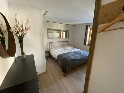 Haus Ingrid في كتسبويل: غرفة نوم مع سرير و مزهرية من الزهور على طاولة