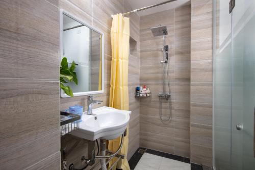 uma casa de banho com um lavatório e um chuveiro em Busan Hotel em Hanói