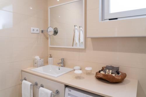 a white bathroom with a sink and a mirror at Rinoterra Minho in Caminha
