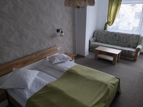 a bedroom with a bed and a couch and a chair at Casa Anda in Sibiu