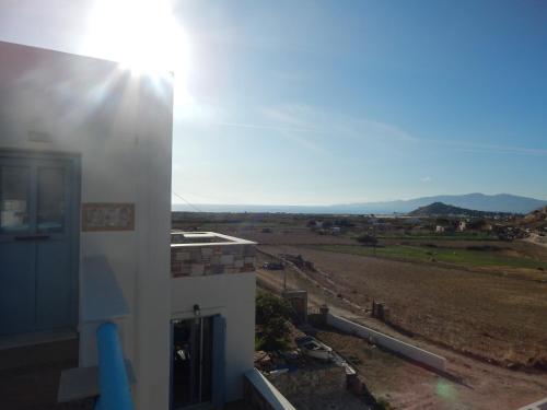 a view of a building with the sun shining at Armonia Studios, Apartments & Villa in Mikri Vigla