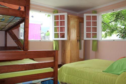 1 Schlafzimmer mit 2 Etagenbetten und 2 Fenstern in der Unterkunft CASAMELIAS "Le camélia" in Cilaos