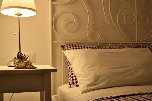シラクーサにあるIL MORO holiday homeのベッド(ヘッドボード付)、テーブル(ランプ付)