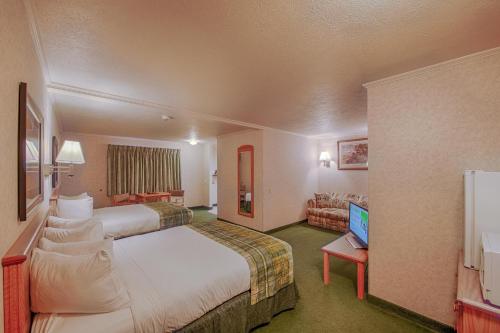 una camera d'albergo con un grande letto e una TV di Brandin' Iron Inn a West Yellowstone