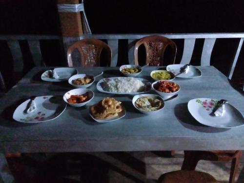 a table with plates and bowls of food on it at Lake Lane Guest Rest in Koggala