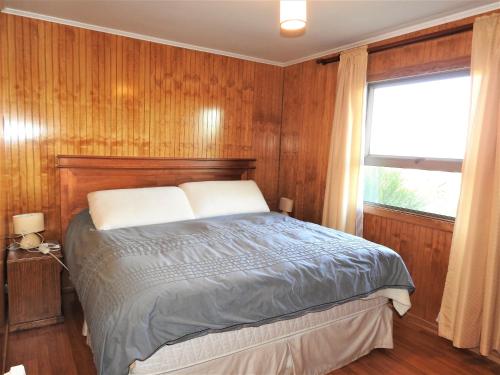 1 dormitorio con cama y ventana en Casa Amoblada Frutillar en Frutillar
