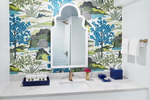 a bathroom with a sink and a blue and white wallpaper at Hotel Simone in Saint Simons Island