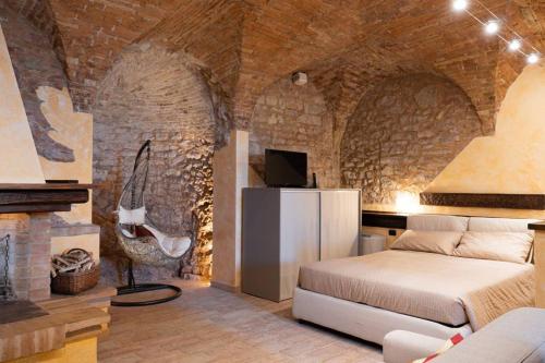 - une chambre avec un lit dans une pièce dotée d'un mur en briques dans l'établissement another brick in the vault, à Spello