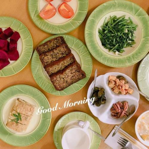 una mesa con platos verdes de comida. en 拇指園民宿, en Guanxi