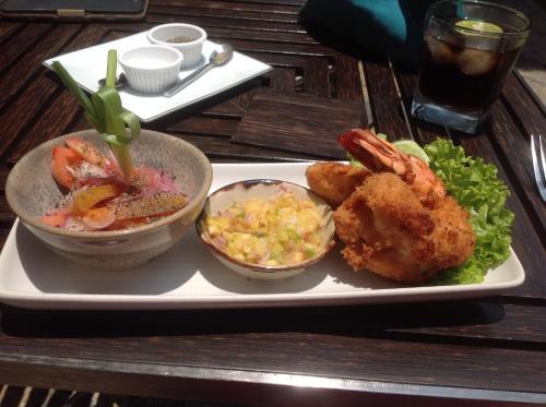 a plate of food with shrimp and salad and a drink at Good Karma Villa in Bentota