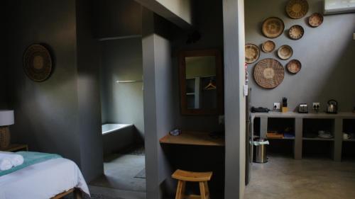 a bedroom with a bed and a bathroom with a tub at Dream of Africa Bush Lodge in Marloth Park