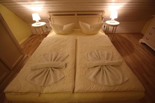 a bedroom with a bed with two bow ties on it at Landhaus Alt Reddevitz in Middelhagen