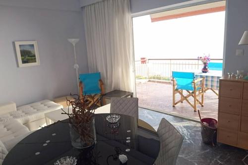 a living room with a table and a view of the ocean at Sunshine House offering spectacular views to Olymp A in Nea Iraklia