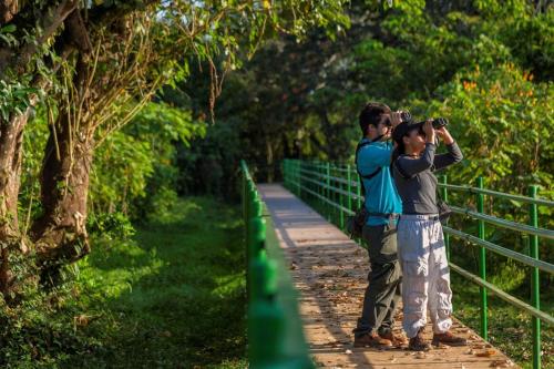 two people standing on a boardwalk taking a picture at Natural Lodge Caño Negro in Caño Negro