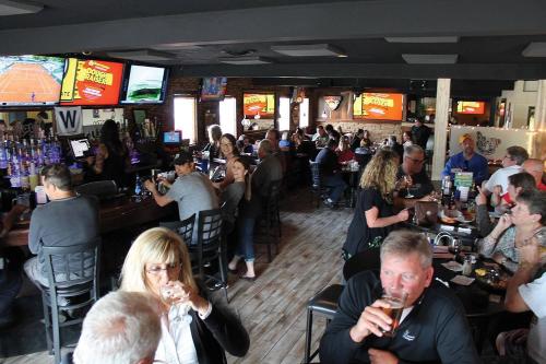 un grupo de personas sentadas en un bar bebiendo vino en Mark III, INN & Suites, en Scottdale