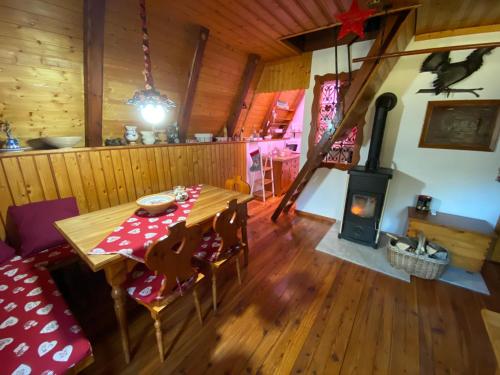 una sala da pranzo con tavolo e stufa a legna di Wooden Cottage a Jesenice