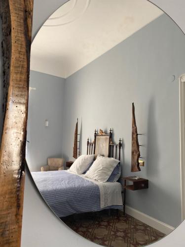 a mirror in a bedroom with a bed at Cortile Umberto in Racalmuto