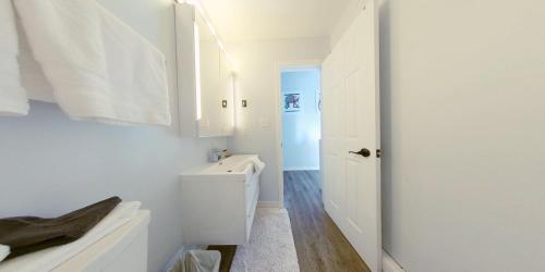 a white bathroom with a toilet and a sink at Artistic Hillside Loft in Blue Mountains