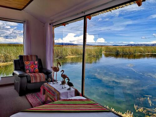 a room with a chair and a view of a lake at Caminos Del Titicaca Lodge in Puno