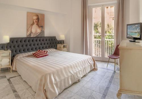 1 dormitorio con 1 cama y una pintura en la pared en Hotel Shelley e delle Palme, en Lerici