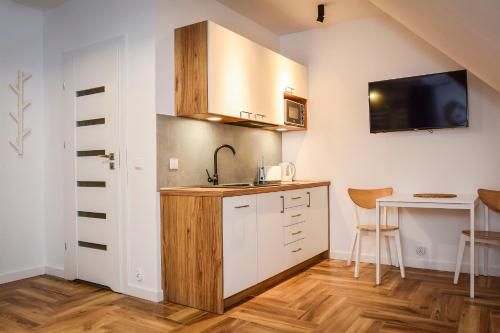 a small kitchen with a sink and a table at Miło Cię widzieć in Łeba