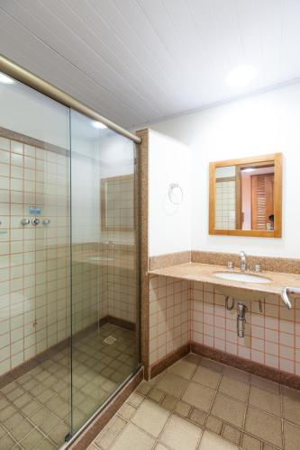a bathroom with a glass shower and a sink at Samba Angra dos Reis in Angra dos Reis