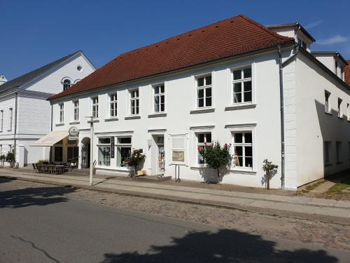 ein weißes Gebäude an der Straßenseite in der Unterkunft DTS Appartements in Putbus