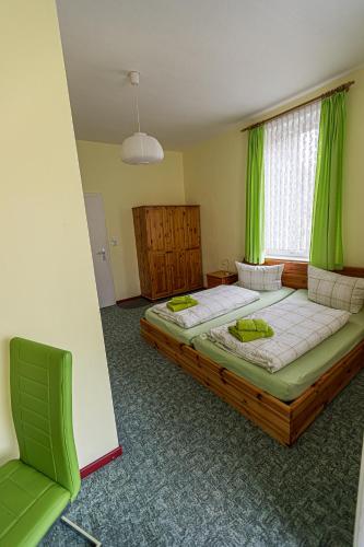 a bedroom with two beds and a window with green curtains at Ski und Biker Hotel Villa Sonnenschein Braunlage am Wurmberg in Braunlage