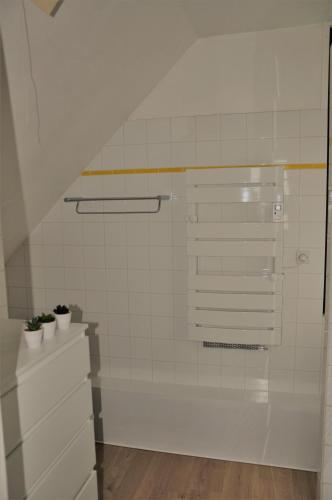 - une salle de bains carrelée de blanc avec deux plantes en pot dans l'établissement Le 246 - Duplex face à la mer pour 4 personnes, Wifi, TV full Sat, Parking, à Wimereux