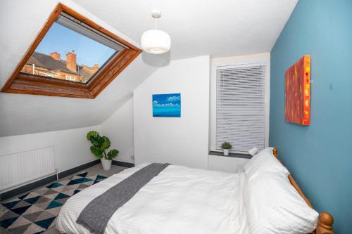Un dormitorio con una cama grande y una ventana en Arthouse - Lovely, Spacious and Elegant 5bed House en Nottingham