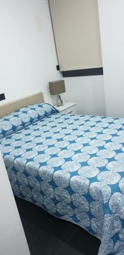 1 dormitorio con 1 cama con edredón azul y blanco en ALTOZANO, en Albacete