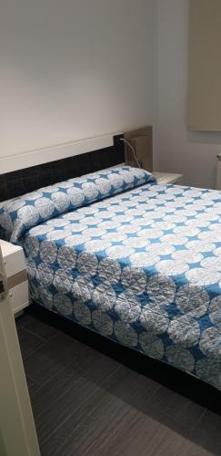 a bed with a blue and white comforter in a room at ALTOZANO in Albacete