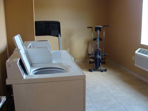 a bathroom with a washing machine and a vacuum at Cobblestone Hotel & Suites - Broken Bow in Broken Bow
