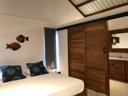 a bedroom with a bed and a wooden door at COCO MANGO Villa in Trèfles