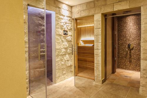 a walk in shower in a bathroom with a glass door at Alpemar Apart Hotel & Spa in Villa Gesell