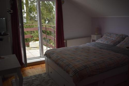 a bedroom with a bed and a sliding glass door at Agroturystyka SZYSZKA in Polnica