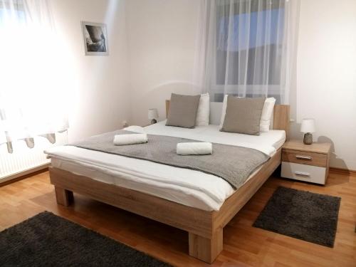 a bedroom with a large bed with two pillows on it at Hanna Apartman in Bük