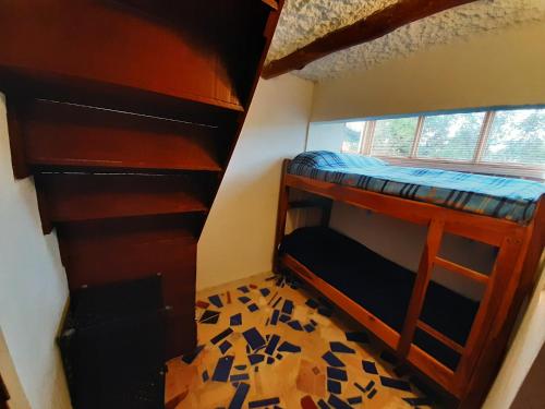 a room with two bunk beds and a window at La Cigarra Casa de Huéspedes in Salento