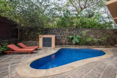 a swimming pool in a backyard with a brick wall at Jet Luxury at Langosta Beach Resort & Villas in Tamarindo
