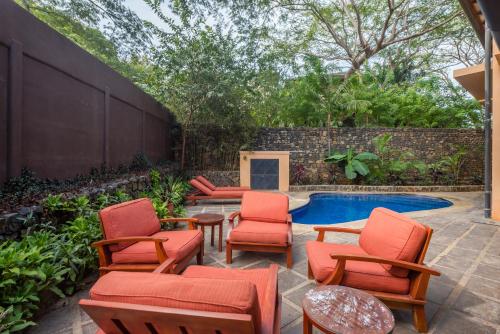 a patio with chairs and a swimming pool at Jet Luxury at Langosta Beach Resort & Villas in Tamarindo