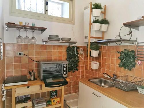 cocina con fregadero y microondas en Lisetta's house, en Monreale