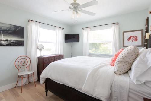 a bedroom with a white bed and a ceiling fan at Light and Breezy in SoSo in West Palm Beach