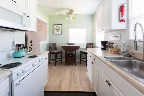 a kitchen with white cabinets and a sink at Light and Breezy in SoSo in West Palm Beach