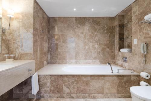 a bathroom with a tub and a sink at Taj Hotel Cape Town - Taj Residence suites in Cape Town