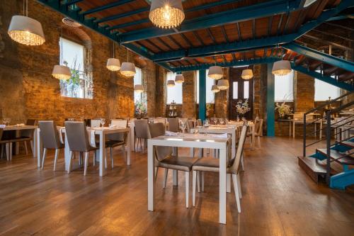 a dining room with white tables and chairs at Hotel de Ilhavo Plaza & Spa in Ílhavo
