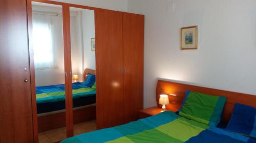 a small bedroom with a bed and a mirror at Torrox Costa in Torrox Costa