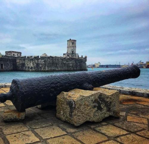 a cannon on a rock next to the water at Hotel Maria del Rocio in Veracruz