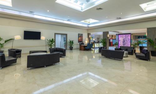 a lobby with couches and chairs and a flat screen tv at Holiday Inn Hotel Port of Miami-Downtown by IHG in Miami